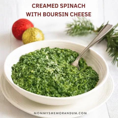 A festive bowl of Creamed Spinach with Boursin Cheese, garnished with Parmesan and lemon zest, styled with holiday decor including evergreen sprigs and ornaments. Perfect for Thanksgiving or Christmas dinner.