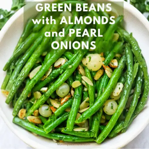Close-up of buttery green beans with toasted almonds and pearl onions in a white serving dish. The beans are vibrant and glistening, styled for a holiday table with a cheeky text overlay: &ldquo;Lettuce change your mind: GREEN BEANS with ALMONDS and PEARL ONIONS.&rdquo;
