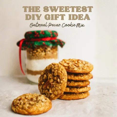 Festive jar of oatmeal pecan cookie mix with red and green holiday fabric, tied with ribbon, next to a stack of golden brown oatmeal pecan cookies&mdash;perfect DIY Christmas gift idea.