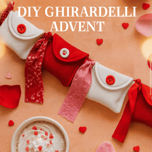 Flat-lay Valentine’s Day scene featuring red and white felt pouches strung with ribbon, surrounded by rose petals, heart confetti, a whipped cream-topped mug of hot chocolate, and a pink heart-shaped cookie with icing text.