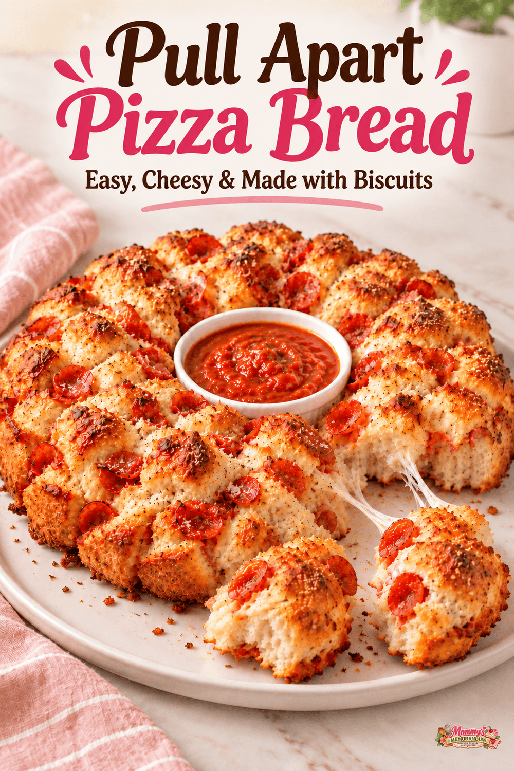 Pepperoni biscuit bread with center dipping sauce and separate cheesy bites, labeled Pull Apart Pizza Bread, with a small Mommy's Memorandum logo.