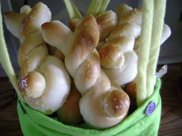Homemade bunny bread rolls shaped with twisted ears and round tails for Easter