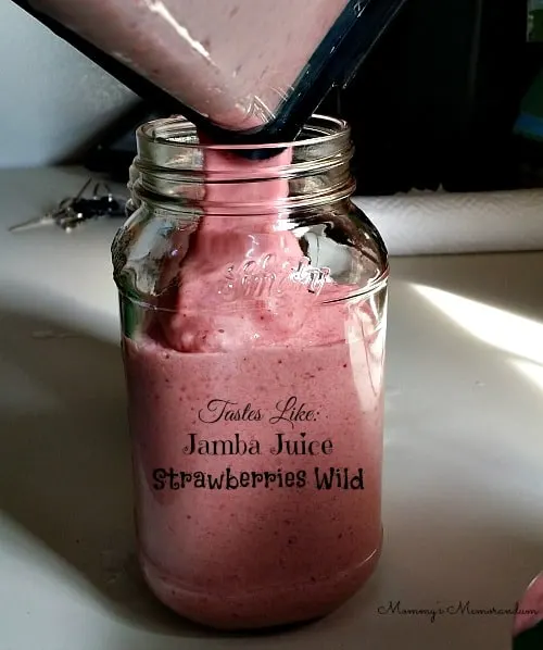 Pouring Copycat Jamba Juice Strawberries Wild Smoothie into a glass jar