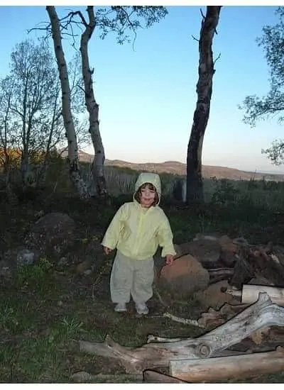 little girl camping with rain jacket