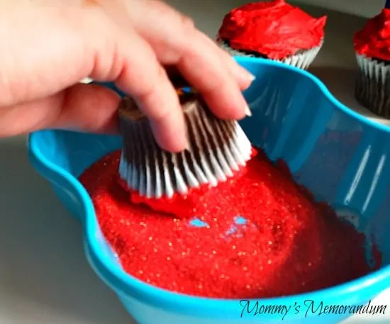 dip the cupcake into the red sugar
