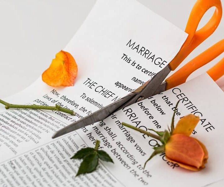 scissors cutting through marriage certificate after divorce