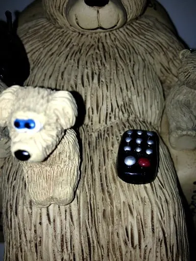 dog with remote on bears on chairs