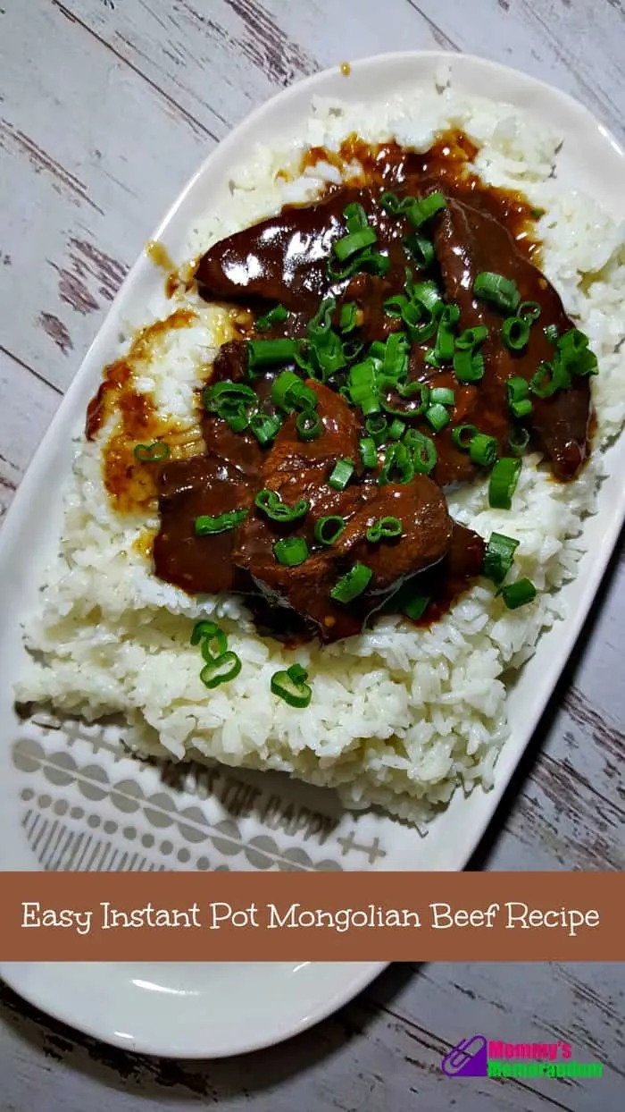 Instant Pot Mongolian Beef over rice on a white plate garnished with chopped green onions