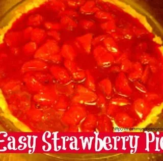 Close-up of a fresh strawberry gelatin pie in a baked crust, topped with whipped cream