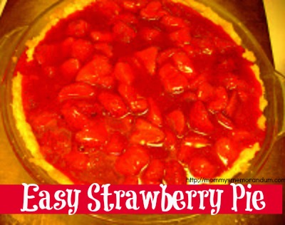 Close-up of a fresh strawberry gelatin pie in a baked crust, topped with whipped cream