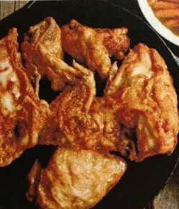 Crispy fried chicken pieces in a skillet, showcasing the best fried chicken recipe, golden and delicious.