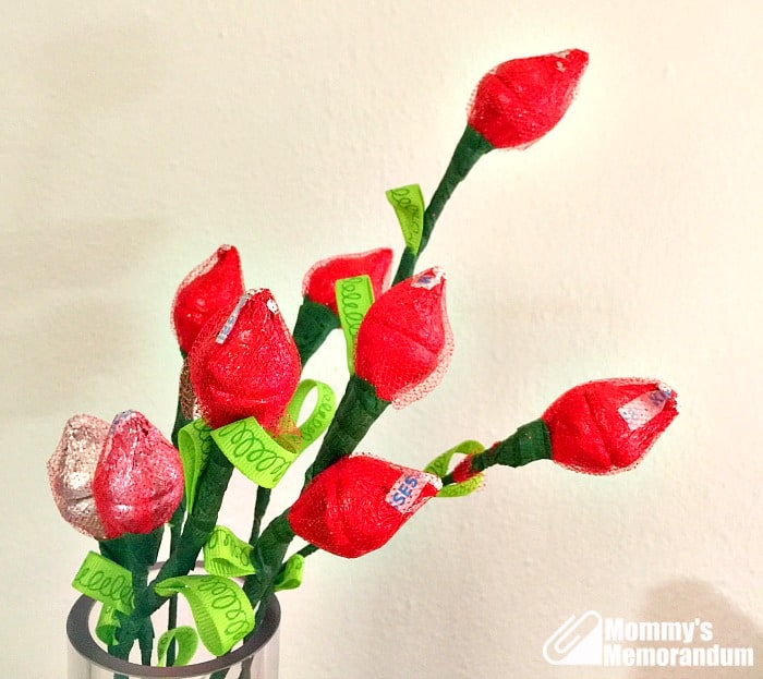 A bouquet of DIY Hershey Kisses roses in a vase, featuring red Hershey Kisses wrapped in glitter tulle.