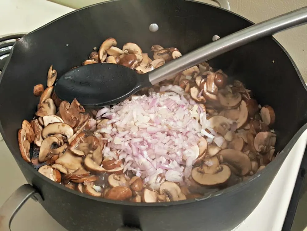 home chef adding scallions and garlic