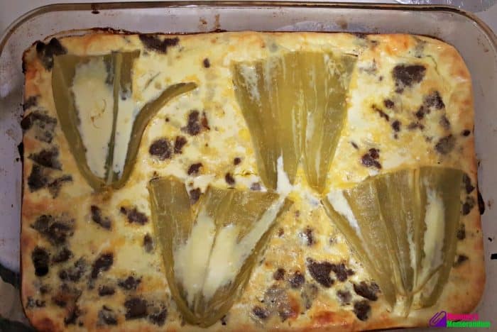 Golden-baked green chile quiche fresh from the oven, showcasing layers of chiles, sausage, and melted cheese.