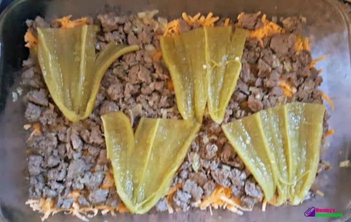 A layer of split green chiles laid flat in a baking pan, creating the first layer for a green chile quiche.