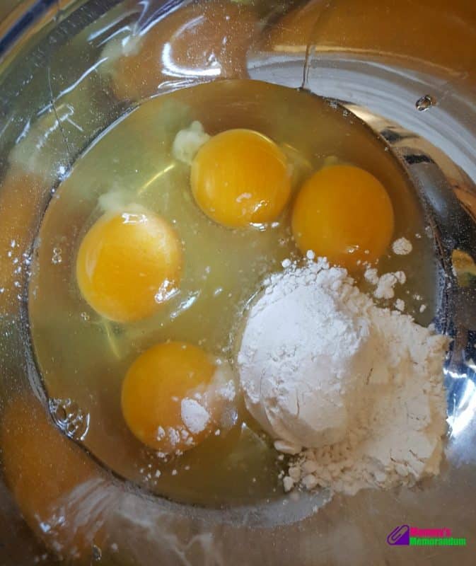 Eggs and flour in a mixing bowl, the first step in preparing the batter for a delicious green chile quiche