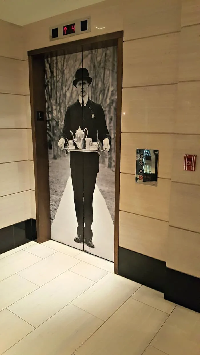 london hotel elevator man with bolo hat