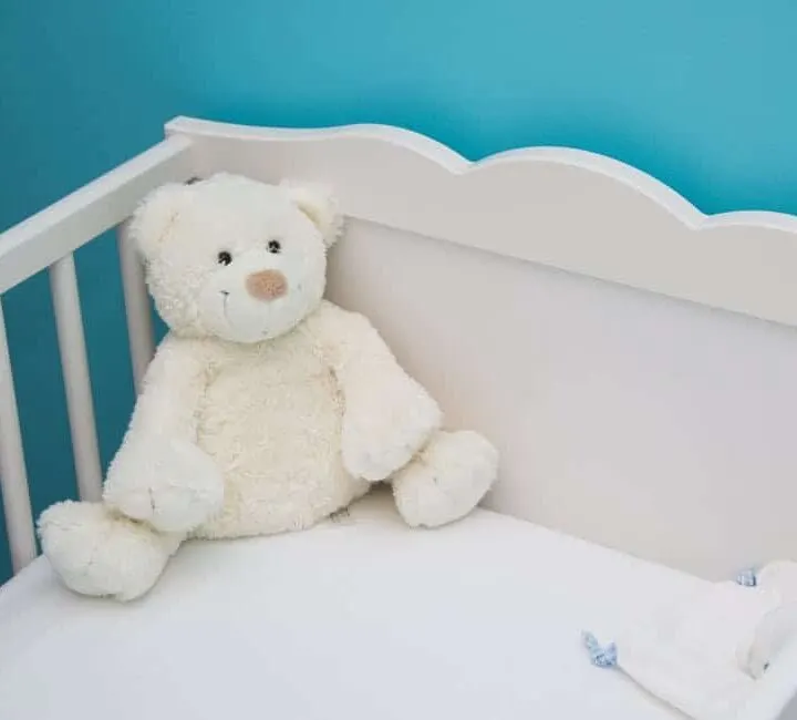 white crib with white teddy bear