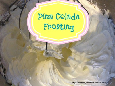 Pina colada frosting being whipped in a mixing bowl with beaters