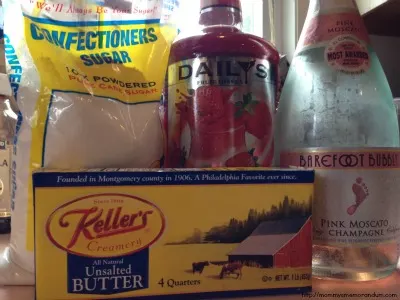 Ingredients for pink champagne buttercream icing including butter, powdered sugar, and champagne