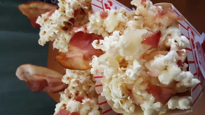A close-up view of piggy popcorn featuring popcorn mixed with crispy bacon pieces