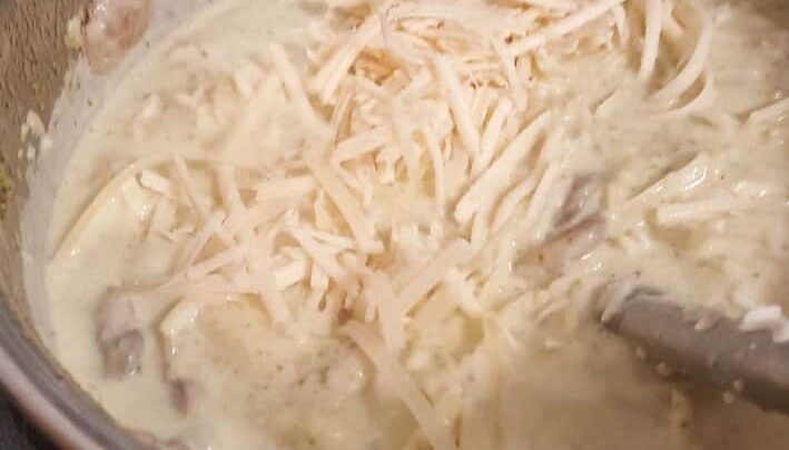 Instant Pot Easy Creamy Chicken Alfredo Pasta stirring in the cheese to the sauce
