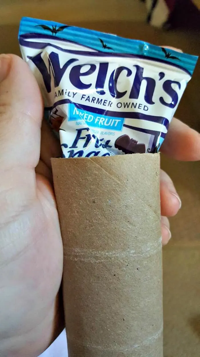tucking Welch's fruit snack in paper roll mummy craft