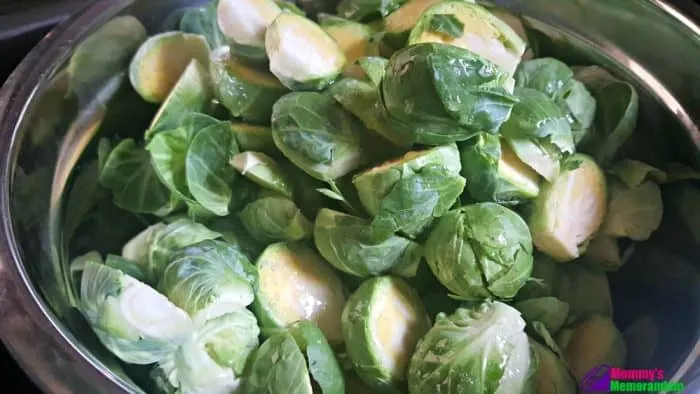 Halved Brussels sprouts drizzled with melted butter, prepared for roasting to a crispy texture